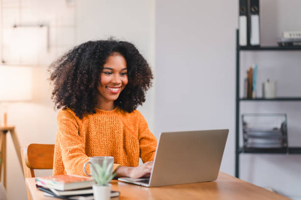 istock Smiling African American woman using a laptop while working from home. 2167080089