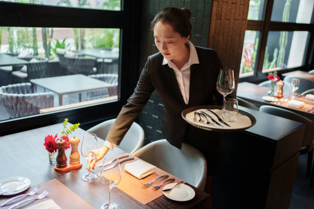 istock Asian waiter placing wine glasses 2167080695