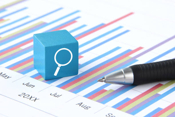 Light blue block with magnifying glass icon placed do business chart sheet