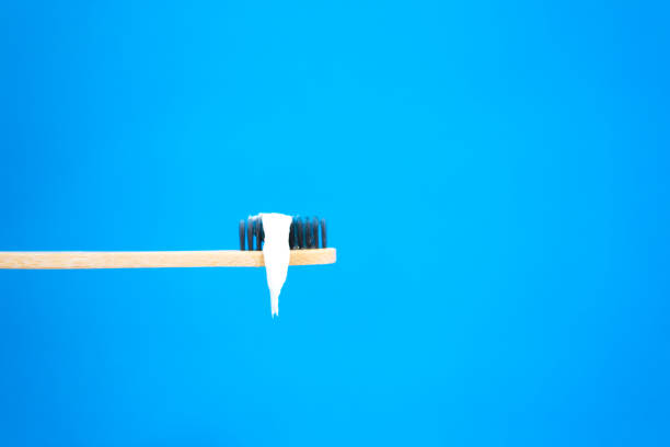 Dripping Toothpaste on Toothbrush, Vibrant Blue Background