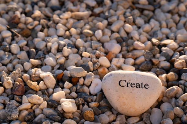 A motivational word rock on gravel at sunset.