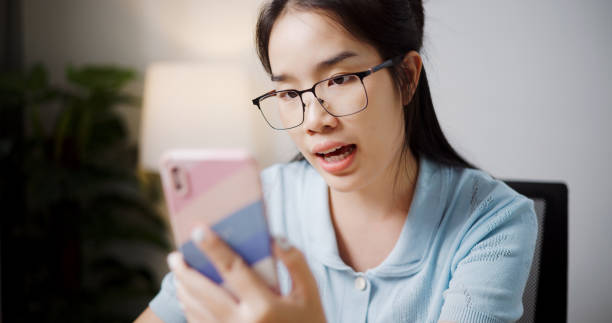 istock Young woman wearing glasses is talking on the phone while writing. 2167094124