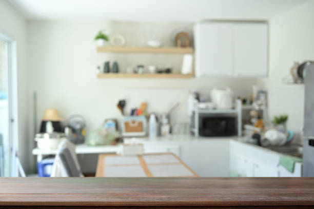istock Wood table with blurred kitchen room in background, space text or showcasing products 2167094634