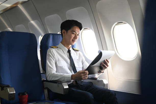 istock Pilot with clipboard sitting near a window in an airplane and checking flight plan or preparing flight procedures 2167094806