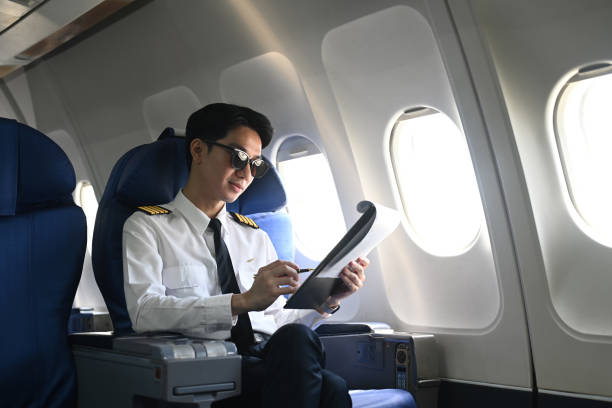 istock Pilot with clipboard sitting near a window in an airplane and checking flight plan or preparing flight procedures 2167094819