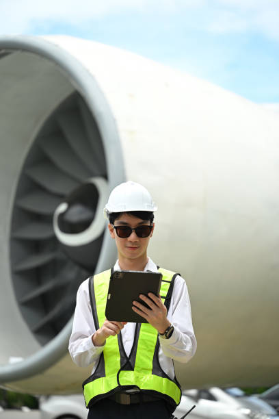 istock Portrait of aviation technician standing in front of a large aircraft engine and using digital tablet 2167094867