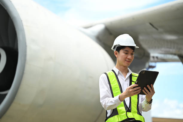istock Young male engineer or aviation technician using digital tablet in front of large aircraft engine 2167094877