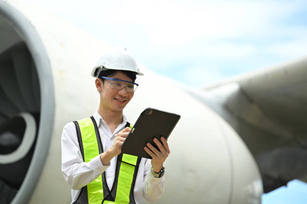 istock Young male engineer or aviation technician using digital tablet in front of large aircraft engine 2167094881