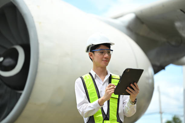 istock Young aviation engineer or inspector standing in front of a large airplane engine checking data on digital tablet 2167094882
