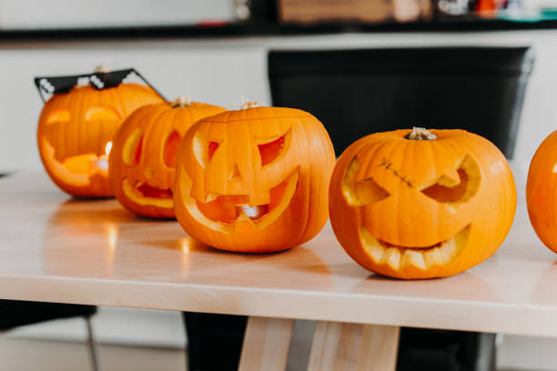 istock Carved jack-o'-lanterns displayed on table at pumpkin carving workshop 2167097295