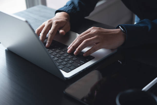 istock Business man hands typing on laptop computer keyboard, searching information, surfing the internet on dark office desk, distance job, online working, business and technology concept 2167098326