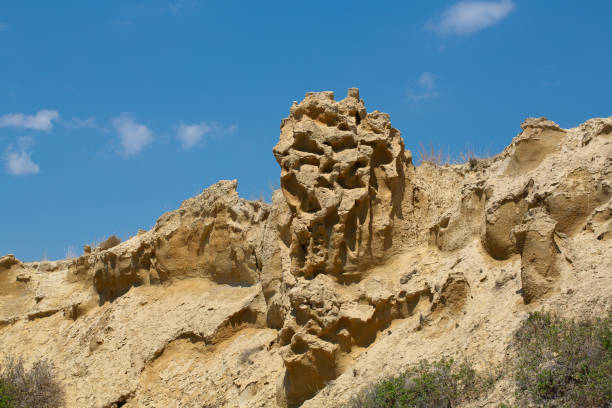 istock Rock formation resembling a face emerging from a cliff on a sunny day 2167099553