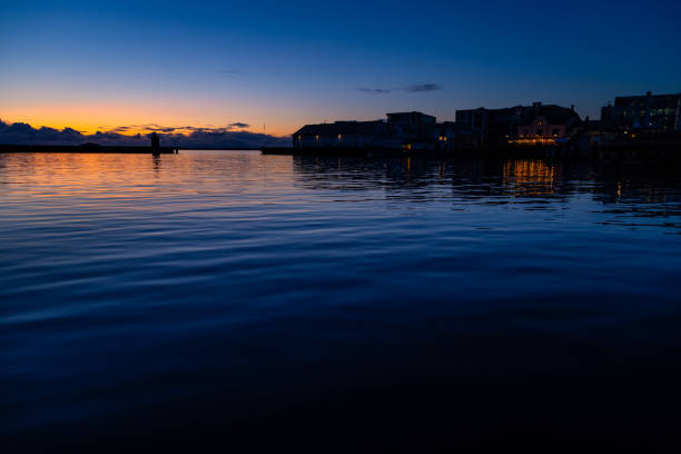 Lastres, Asturias, Spain. August 11, 2022. Dawning on the breakwater. Fishing boat returning. Idyllic landscape
