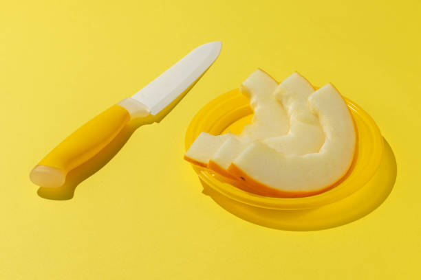 Sliced Melon with Knife on Bright Yellow Background - Fresh Summer Fruit