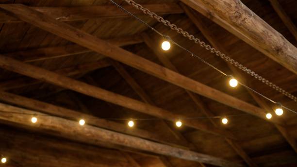 istock Ceiling lamp with warm light on a wooden ceiling. Wooden ceiling with light bulbs. 2167106633
