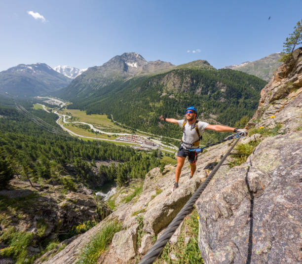 istock Rock Climber Balancing Joyfully on Cliffside with Majestic Valley View 2167108747