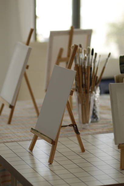 istock paint brushes and small easels on the table 2167112250