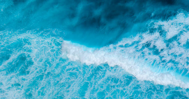 istock Turquoise ocean sea water white wave pattern splashing deep blue sea. Seascape dark ocean background wave splash on rock. Tropical sea beach in summer seaside outdoor. Water Surface blue wave pattern 2167116894