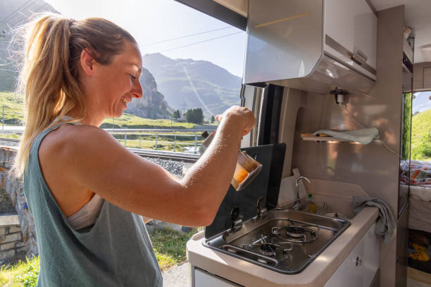 istock Woman Pouring Coffee in Campervan with Mountain View 2167126802