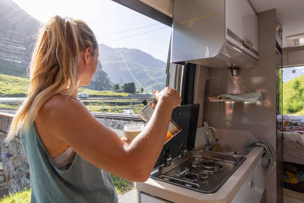istock Woman Pouring Coffee in Campervan with Mountain View 2167126949