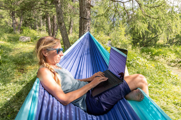istock Woman Working on Laptop While Relaxing in Forest Hammock 2167130122