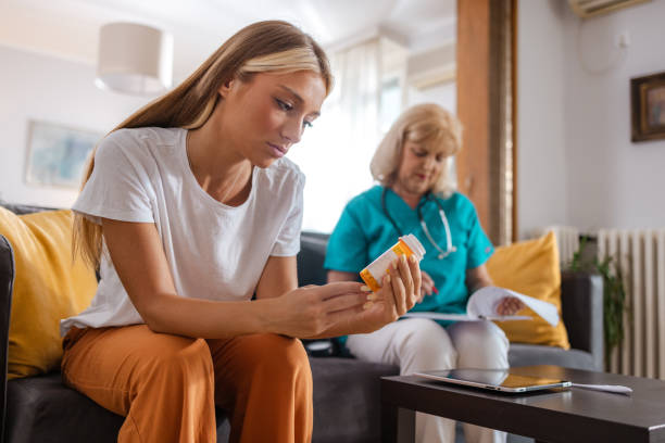 istock Young Woman Examining Pill Bottle with Concern 2167134467