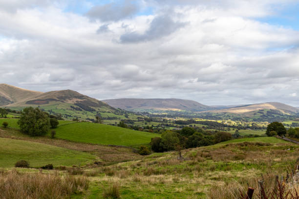 istock Scenic view of rolling hills with lush greenery under a cloudy sky. 2167138570