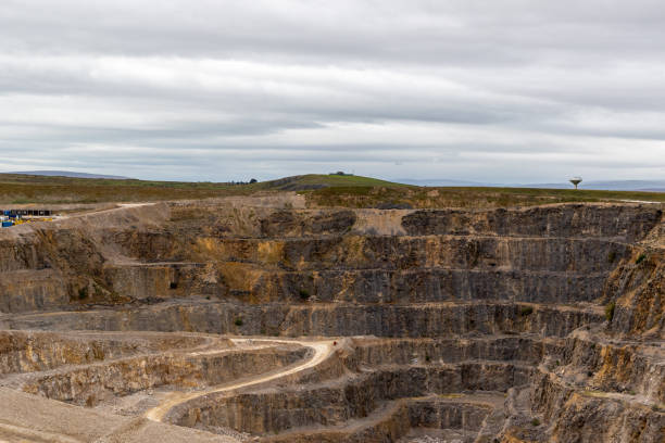 istock Expansive open-pit mine with winding roads under a cloudy sky. 2167140333