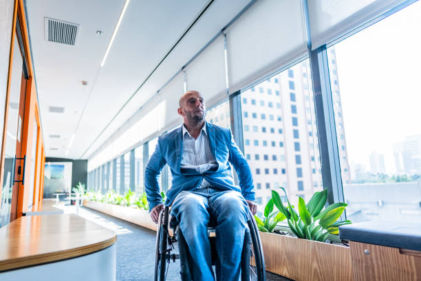 istock Wheelchair businessman walking at corridor's office 2167140607