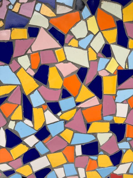Stock photo showing close-up view of a randomised mosaic wall decoration that has been created by using a mixture of broken pottery. These smashed pieces have been carefully laid out on some evenly spread tile adhesive, taking care to keep them all level, being grouted once dry and set in place.\n\n* Not AI modified *