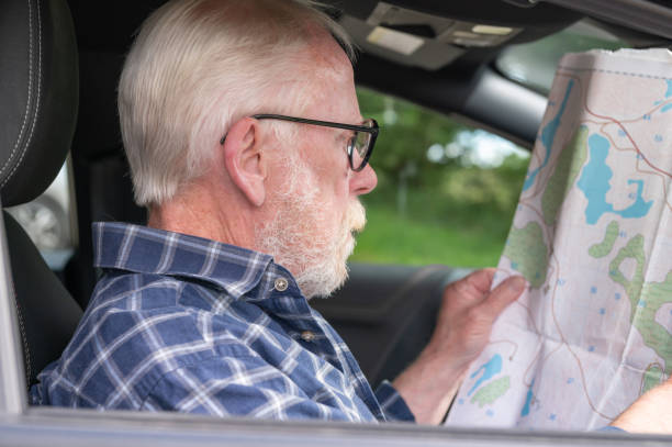 istock Senior man sitting in a car looking at a map 2167145484