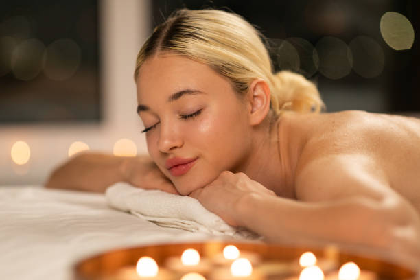 istock Woman Laying on Bed Surrounded by Candles at Spa 2167146109