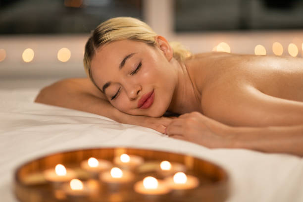 istock Woman Laying on Bed Surrounded by Candles at SPA 2167146168