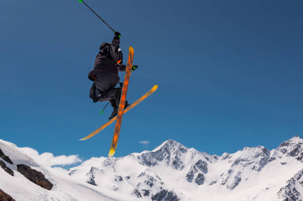 Stylish skiing trick in snowy high sharp mountains. The athlete is flying.
