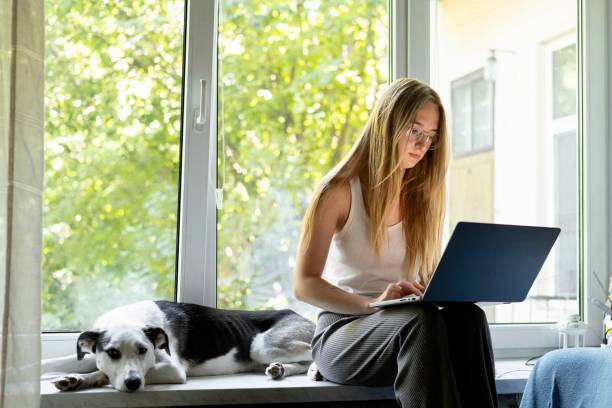 istock Young woman working on her laptop at home 2167148600