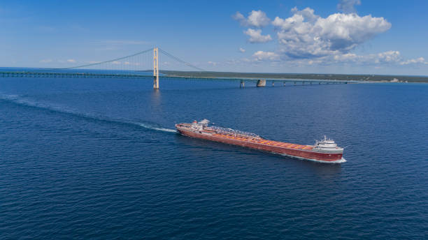 In the Straits of Mackinac, the Great Lakes freighter, Wilfred Sykes passes the Mackinac Bridge that connects the lower and upper peninsulas in the state of Michigan.