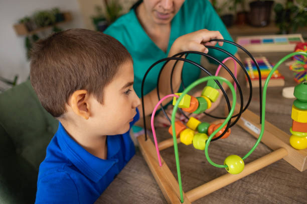 istock Nurse Helping Boy with Autism Play 2167162149