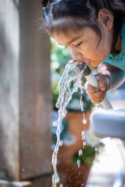 istock A young girl is drinking water from a hose 2167164057
