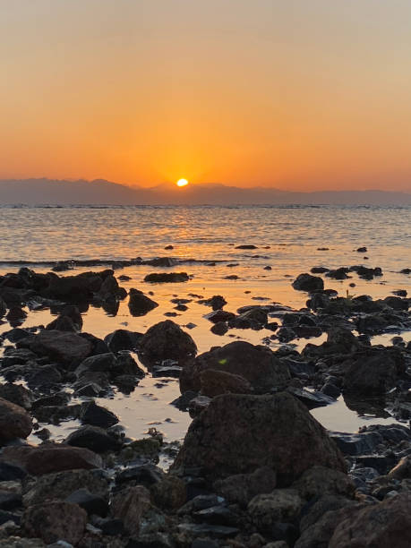 istock sunrise over the beach and rocks 2167164403