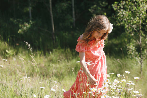 A beautiful little girl, nine years old, picking flowers in a meadow.