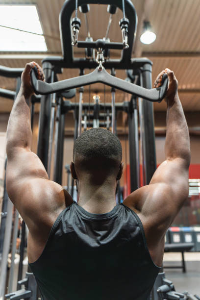 istock Muscular black man training back in the gym with pulleys 2167165128