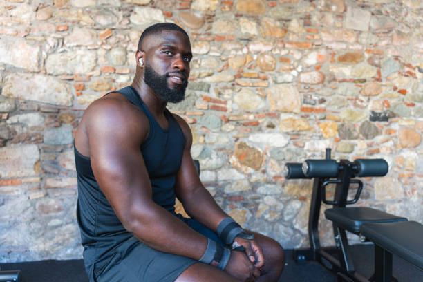 istock Black man in a tank top sitting on a gym bench 2167166292