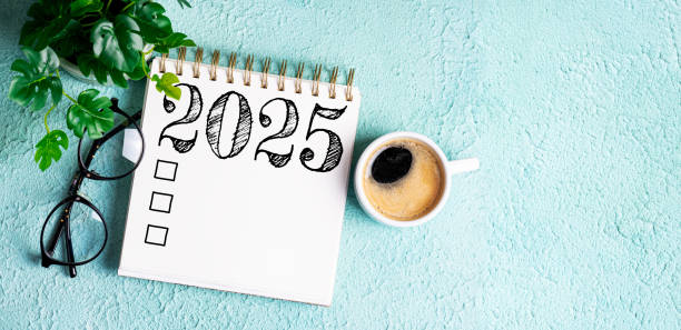 istock New year resolutions 2025 on desk. 2025 resolutions list with notebook, coffee cup on table. Goals, resolutions, plan, action, checklist concept. New Year 2025 template 2167166444