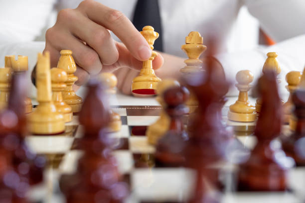 istock Mans hand and chess pieces on the board 2167168297