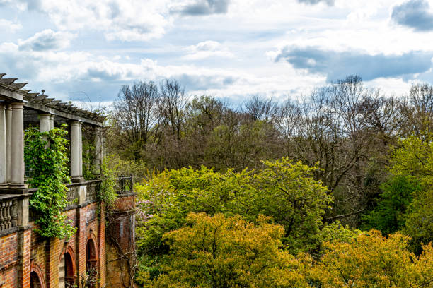 istock Old brick building with classic columns overlooking a lush green forest under a cloudy sky in The Hill Garden and Pergola in London. 2167168974