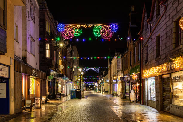 istock Deserted evening street with festive lights and illuminated shopfronts, creating a cozy atmosphere in a quaint town in Fort Williams, Scotland. 2167169314