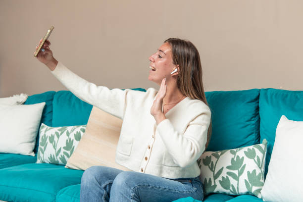 istock young blonde woman making video call with smartphone while sitting on home sofa 2167171786