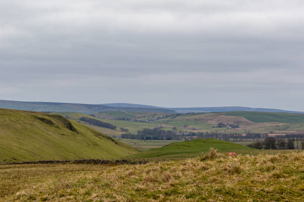 istock Rolling hills with green fields under a cloudy sky, depicting tranquil rural landscape in Peak District, England. 2167171819