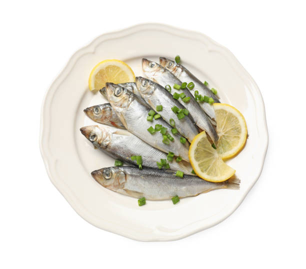 istock Fresh raw sprats, green onion and cut lemon isolated on white, top view 2167182720