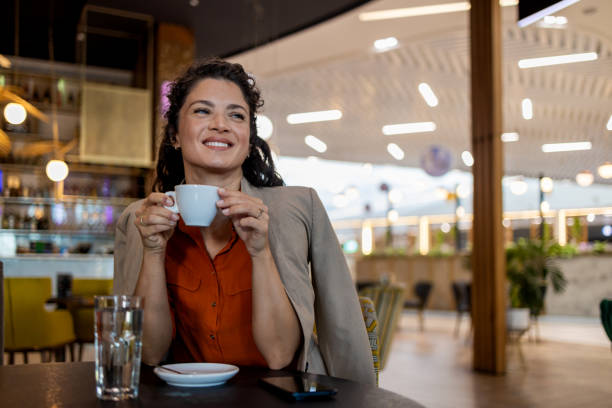 istock Woman enjoying coffee in a modern cafe setting 2167188780